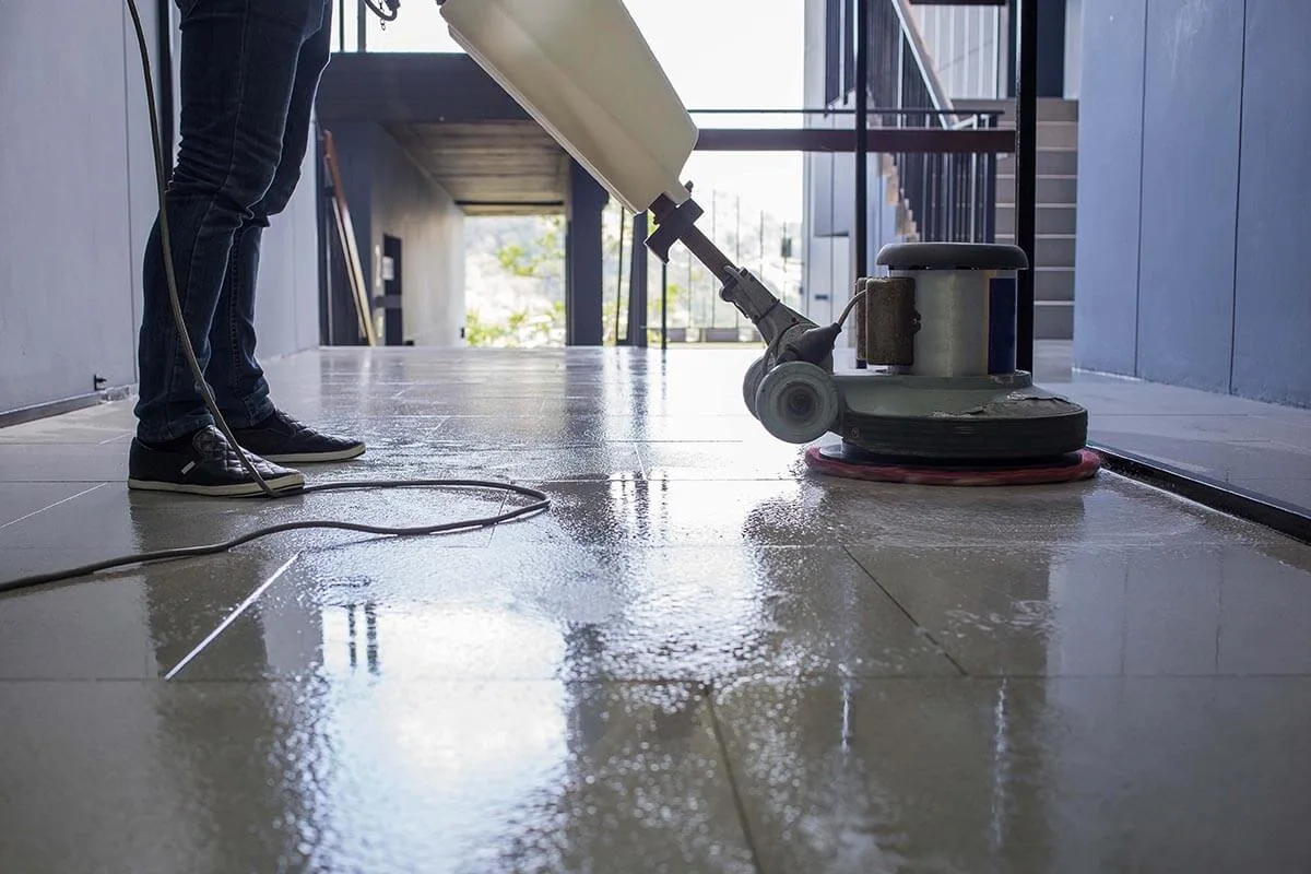 Floor scrubbing machine cleaning a commercial kitchen floor